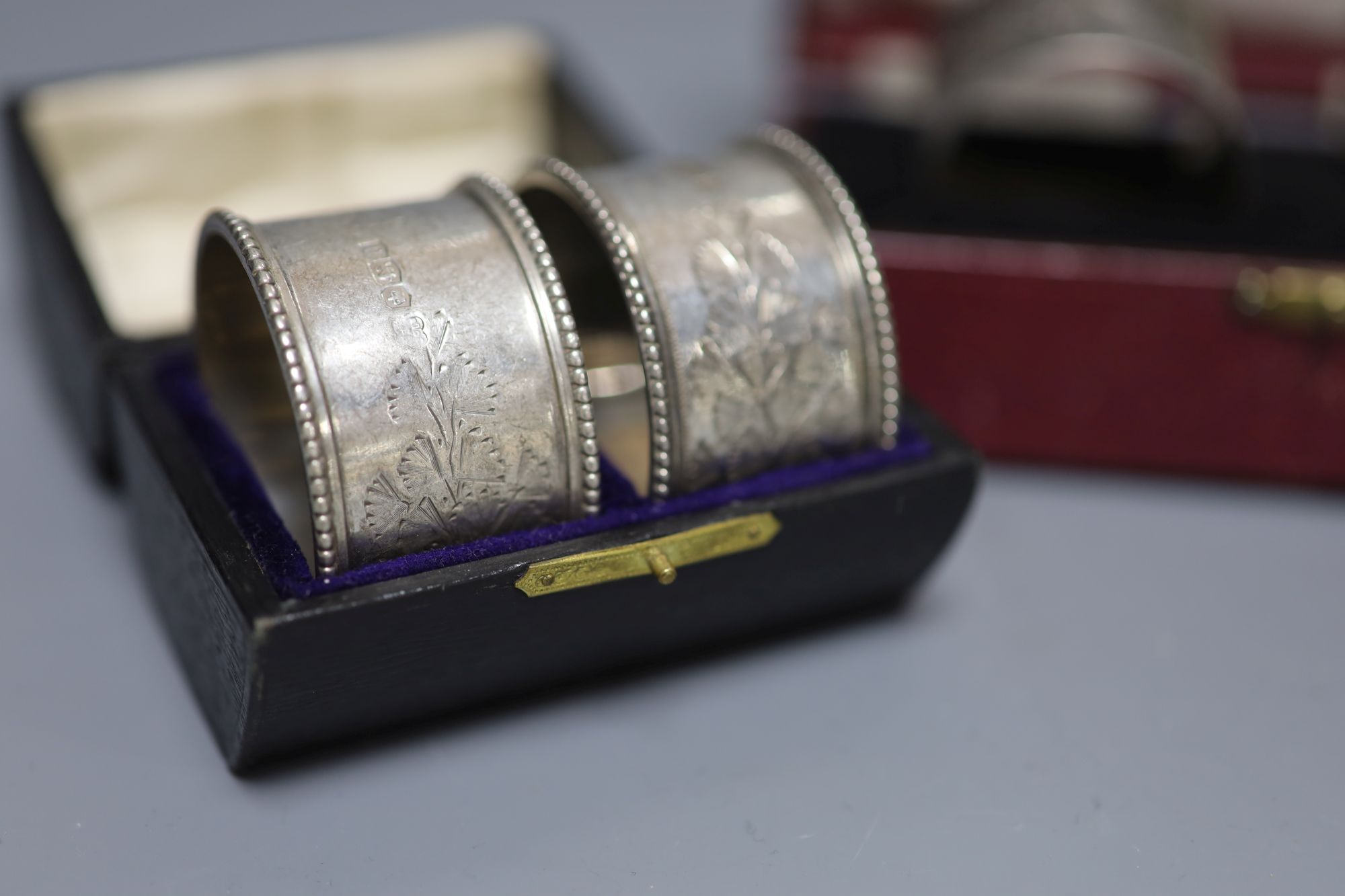 Three cased pairs of Edwardian and later silver napkin rings.